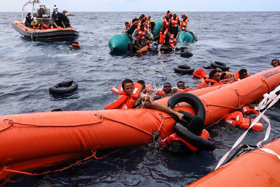 Migrants who fell in the water struggle to cling on to a a float before being rescued by a humanitarian rescuers, around 35 miles away from Libya, in the Mediterranean Sea. (AP)