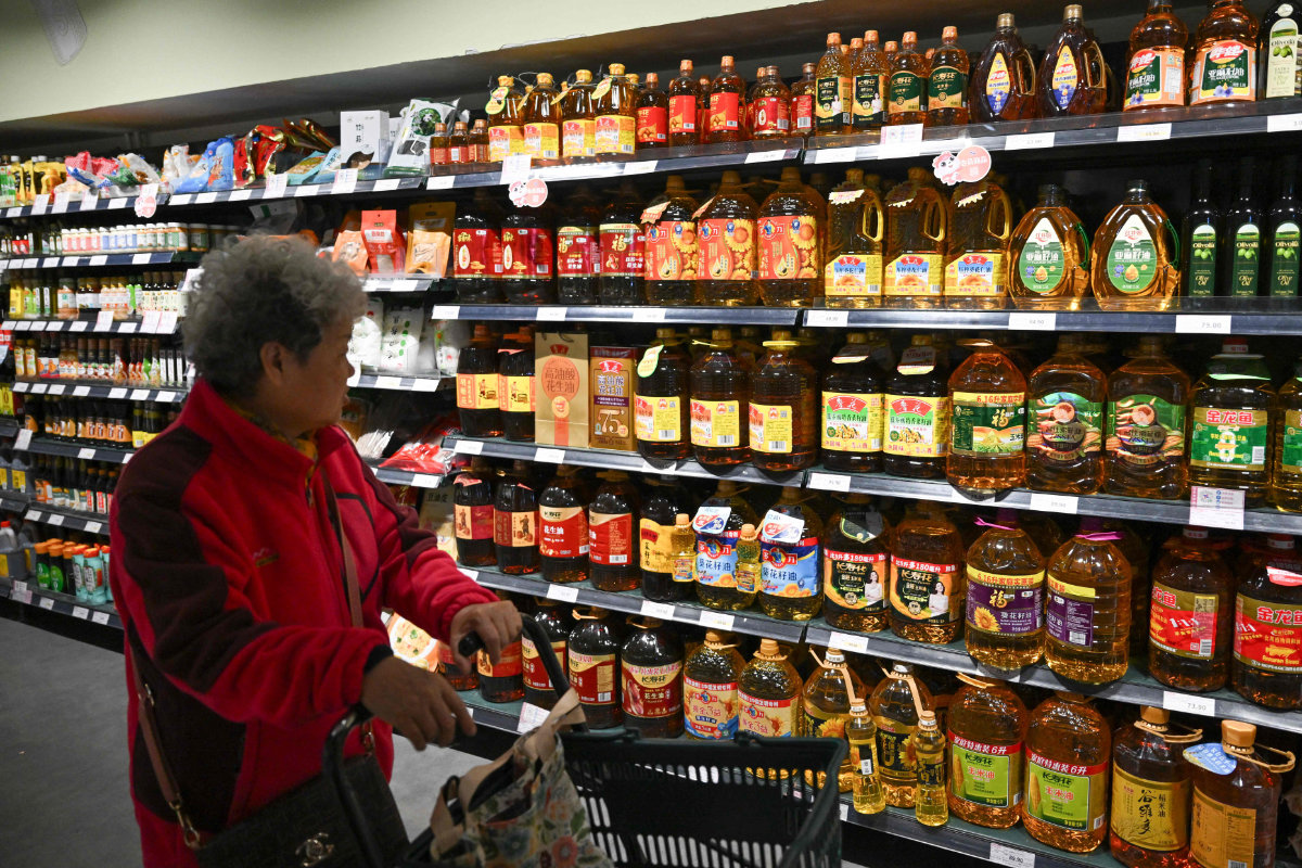 A shopper browses past shelves of cooking oil for sale at a supermarket in Beijing on October 15, 2025. China on Saturday it was open to anew round of trade talks with the US after President Trump slammed China's halt of American soybean purchases as an "economically hostile act," warning October 14 that his country could in turn stop buying cooking oil from the world's second-biggest economy. (AFP)