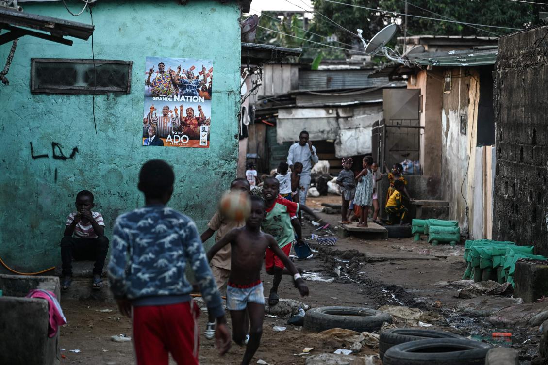 Above, a campaign poster of Ivorian President Alassane Ouattara, who is running for re-election, in a poor sub-neighborhood of the Adjame commune in Abidjan on Oct. 17, 2025. (AFP)