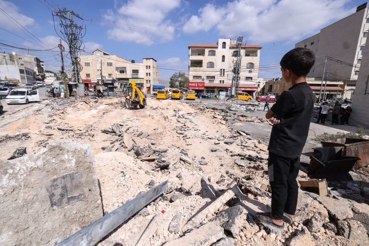A Palestinian child looks on as he stands on the edge of a damaged street following an Israeli raid on the occupied West Bank city of Tubas, Oct. 19, 2025. (AFP)