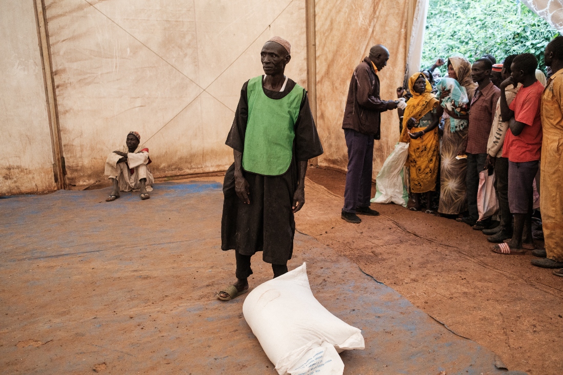 A man stands ready to carry a bag of sorghum at a food distribution site in Maban. (AFP)