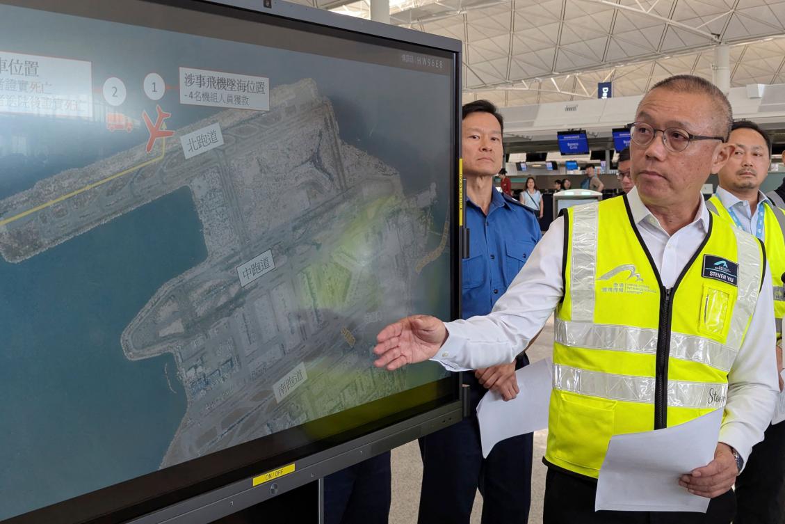 Steven Yiu, Airport Authority Hong Kong’s executive director of airport operations, speaks while standing beside a screen showing the location where a Boeing 747-400 cargo aircraft skidded into the sea. (AFP)