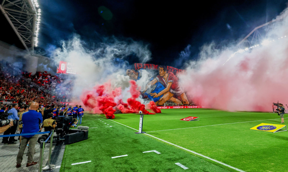 Smoke from flares thrown by fans fills the field before the soccer derby between Maccabi Tel Aviv and Hapoel Tel Aviv was called off Sunday after pregame disturbances led police to deem it unsafe to proceed at Bloomfield Stadium in Tel Aviv, Israel, Sunday, Oct. 19, 2025 . (AP)