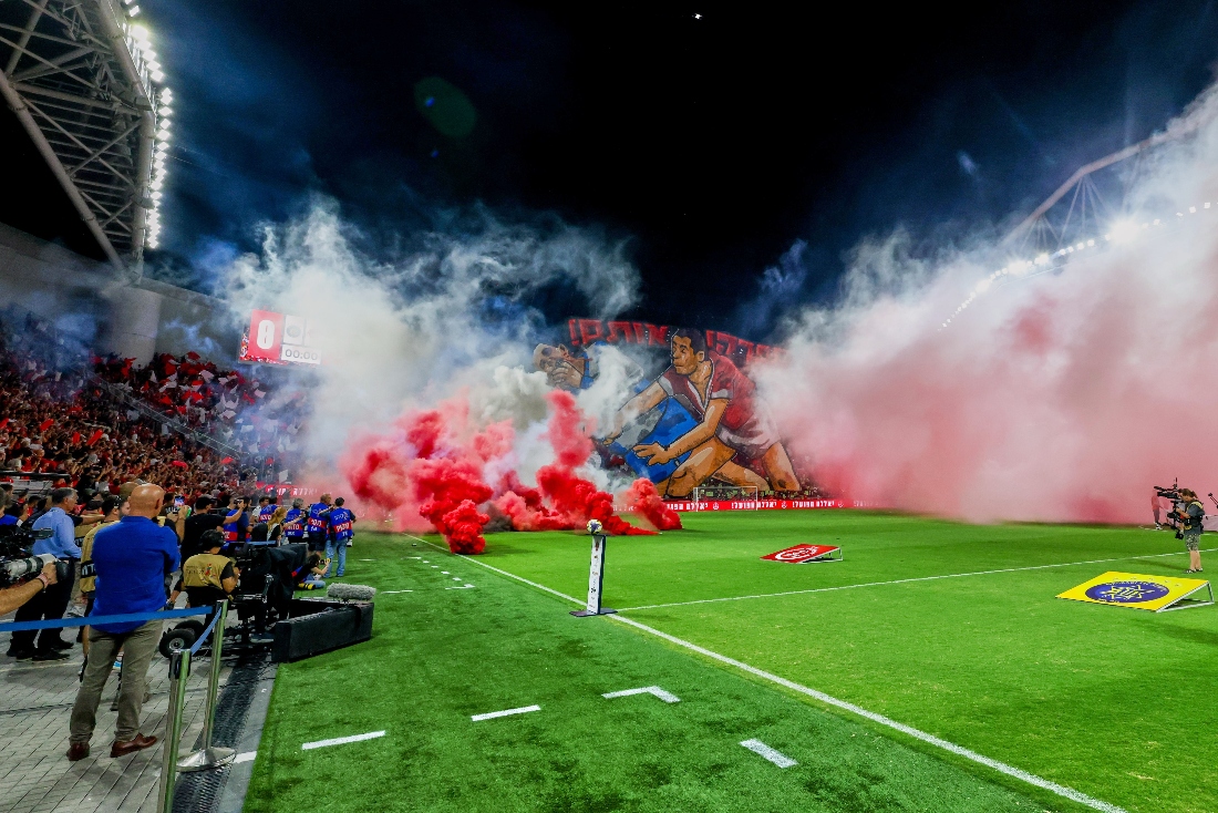 Smoke from flares thrown by fans fills the field before the soccer derby between Maccabi Tel Aviv and Hapoel Tel Aviv in Tel Aviv, Israel. (AP)