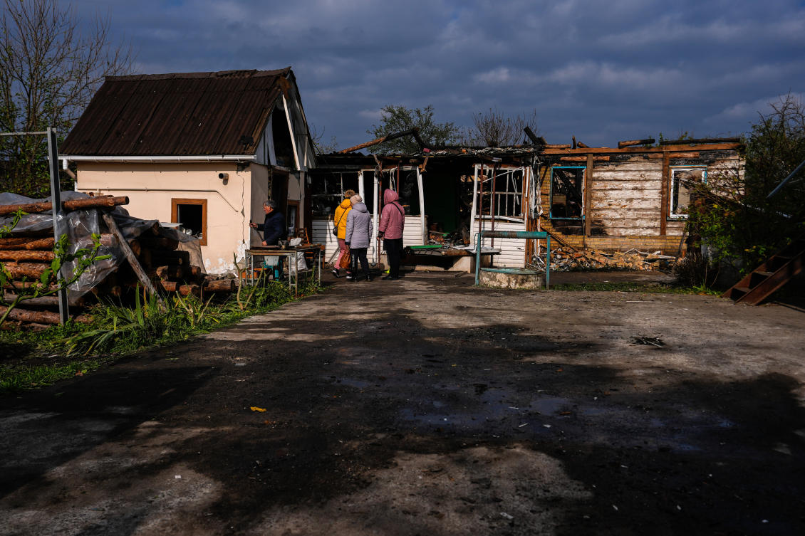 People look at a house damaged in a Russian attack, where a family was killed, Wednesday, Oct. 22, 2025, in Kyiv, Ukraine. (AP Photo/Julia Demaree Nikhinson)