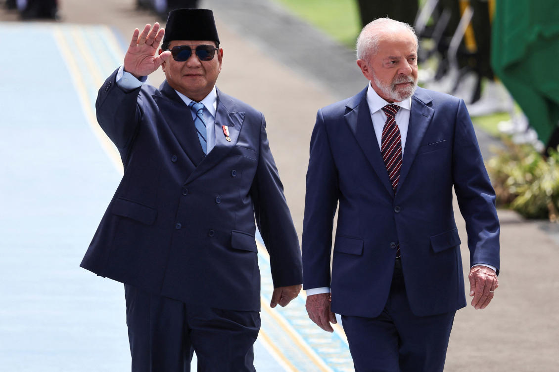 Indonesia's President Prabowo Subianto waves as he walks with Brazil's President Luiz Inacio Lula da Silva during a welcoming ceremony upon their meeting at Merdeka Palace in Jakarta, Indonesia, October 23, 2025. REUTERS/Willy Kurniawan