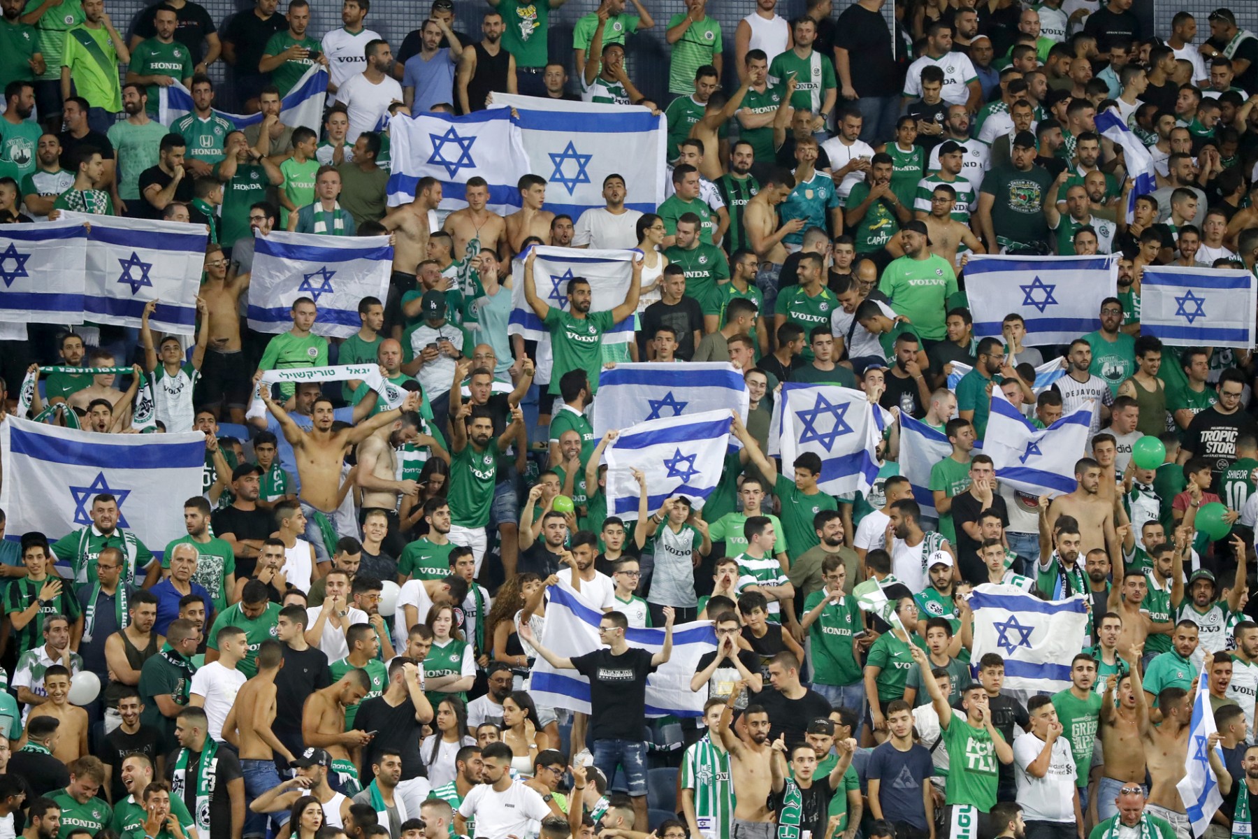 Maccabi fans cheer for their team prior to the second leg of the Europa league second round qualifier football match between Maccabi Haifa and RC Strasbourg at the Sammy Hofer stadium in Haifa on August 1, 2019. (File/AFP)