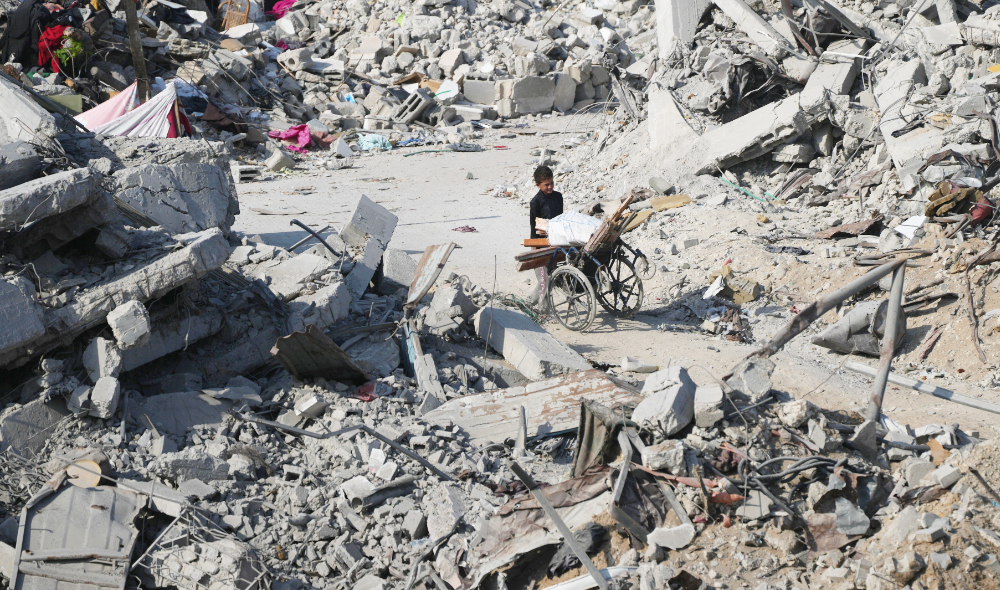 A boy pushes a wheelchair through the rubble of buildings destroyed in the war between Israel and Hamas, in the al-Nafaq area of the Sheikh Radwan neighborhood in Gaza City, Friday, Oct. 24, 2025. (AP)