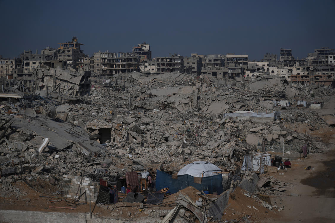 A girl stands outside a tent that shelters her family among the ruins of their home destroyed in the war between Israel and Hamas, in the al-Nafaq area of the Sheikh Radwan neighborhood in Gaza City, Friday, Oct. 24, 2025. (AP Photo/Abdel Kareem Hana)