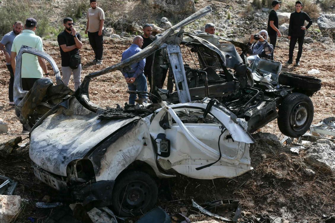 People inspect the wreckage of a vehicle targeted by an Israeli strike in the southern Lebanese village of Haruf on October 25, 2025. (AFP)