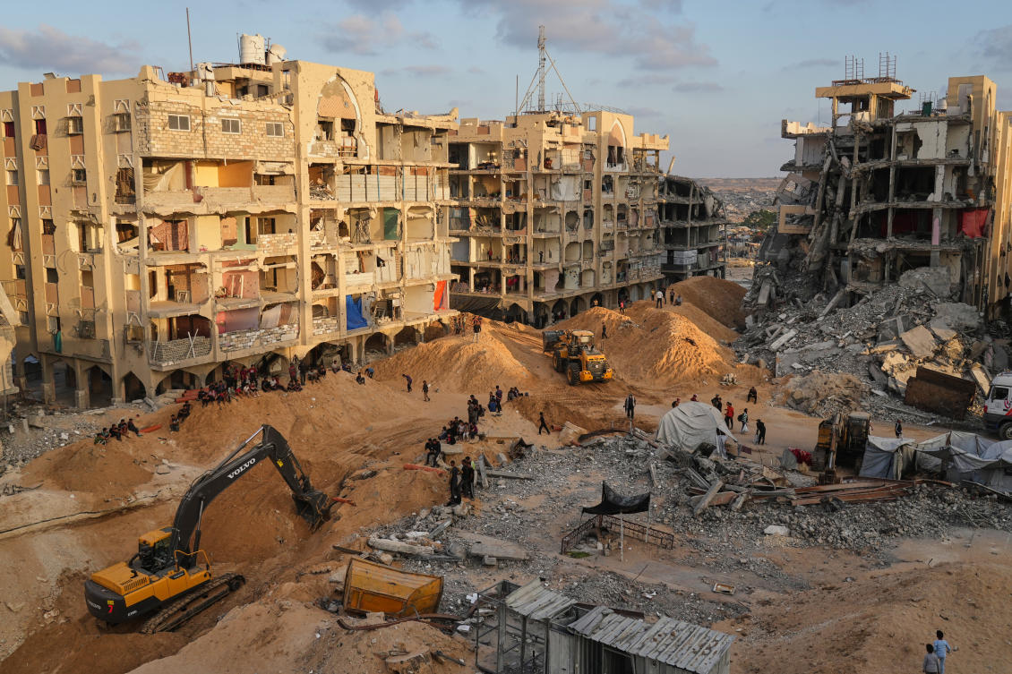 Palestinians watch machinery and some workers from Egypt searching for the bodies of hostages at Hamad City, in Khan Younis, southern Gaza Strip, Sunday, Oct. 26, 2025. (AP)