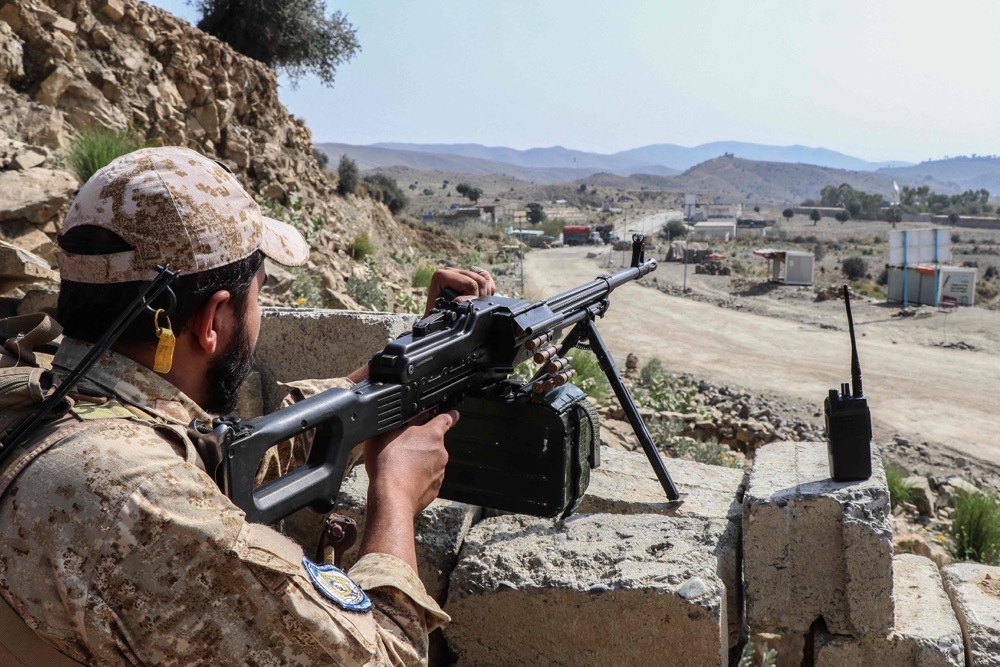 A Taliban security personnel stands guard along a road near the Ghulam Khan zero-point border crossing between Afghanistan and Pakistan. (AFP)