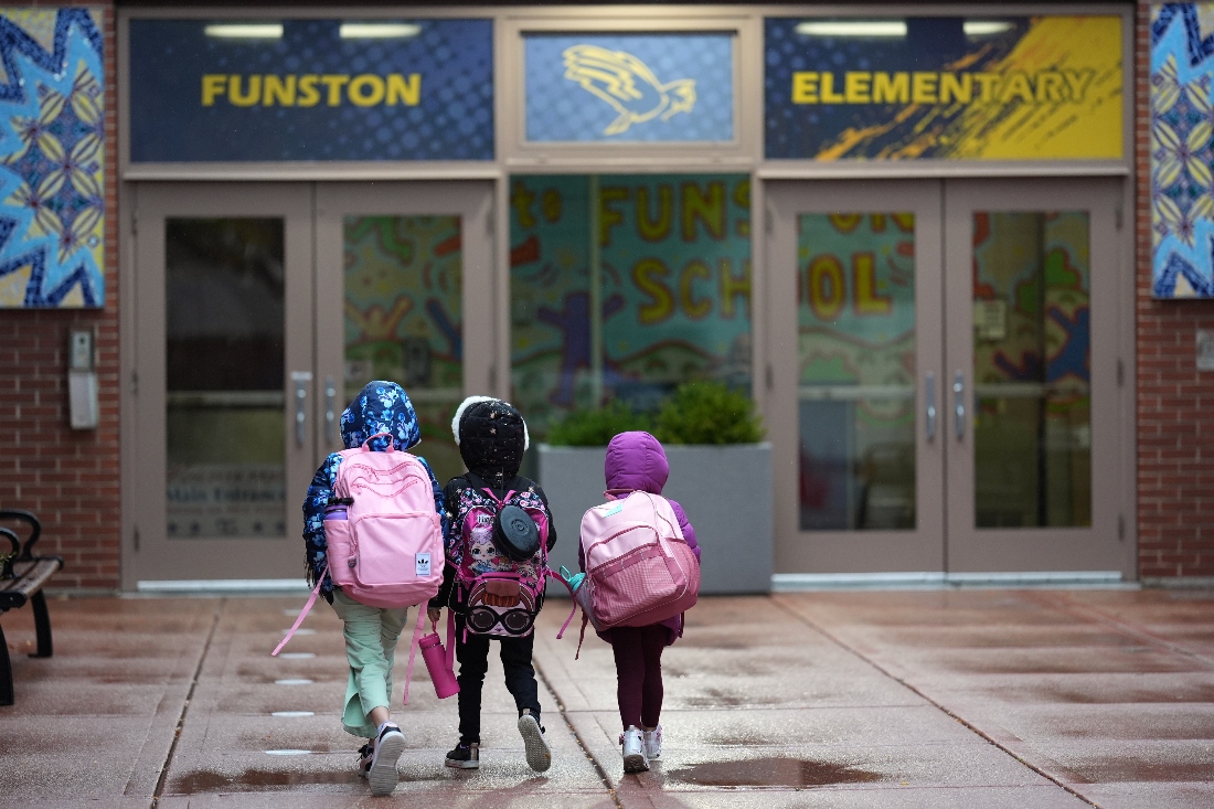 Three sisters, whose single mother fears being mistakenly detained by federal immigration agents because she is of Puerto Rican descent and speaks Spanish, walk into Funston Elementary School in Chicago's Logan Square neighborhood. (AP)