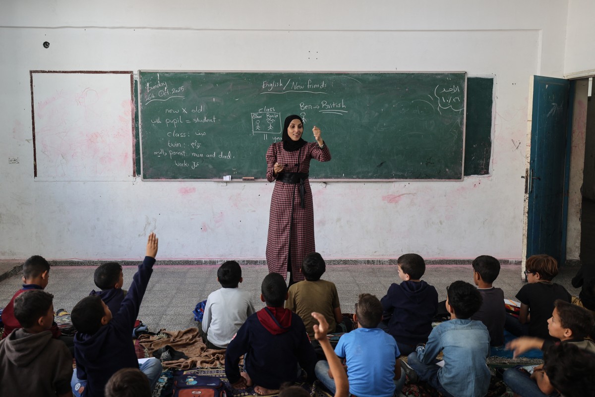 Palestinian schoolboys listen to their teacher at a school in the Nuseirat refugee camp, in the central Gaza Strip, Oct. 26, 2025. (AFP)