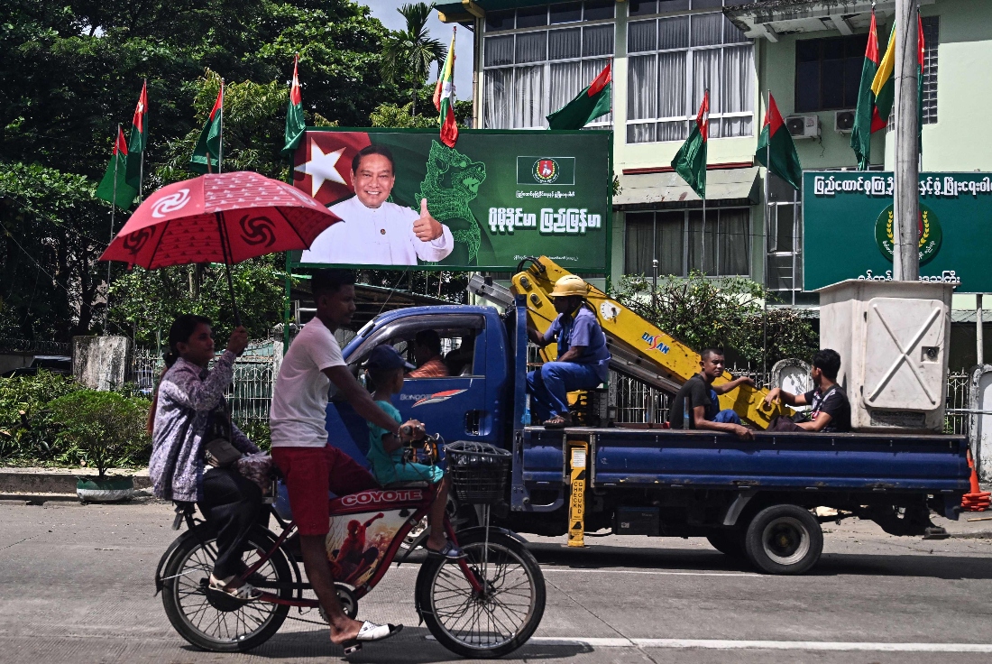 People drive past an election campaign billboard of Myanmar's chairman of the army-backed ruling Union Solidarity and Development Party (USDP) Khin Yi ahead of the start of the election campaign in Yangon. (AFP)
