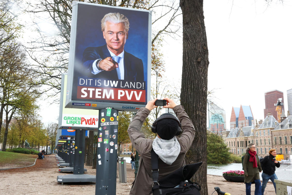 A person takes a picture of an election campaign poster of the Party for Freedom (PVV) leader Geert Wilders on the eve of the Dutch parliamentary election, in The Hague, Netherlands, October 28, 2025. REUTERS/Yves Herman