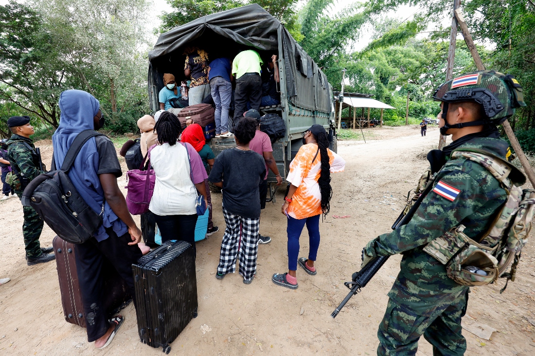 People from various countries, who were working in the KK Park compound in Myanmar and crossed to Thailand via the Moei river, board a vehicle as Thai soldiers keep watch in Mae Sot District, Tak Province. (AFP)