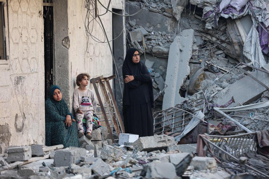 A woman and a child sit amid the rubble of a house destroyed in an overnight Israeli strike in Gaza City on Wednesday. (AFP)