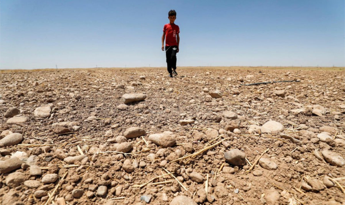 A boy walks through a dried up agricultural field in the Saadiya area, north of Diyala in eastern Iraq. (AFP/File)