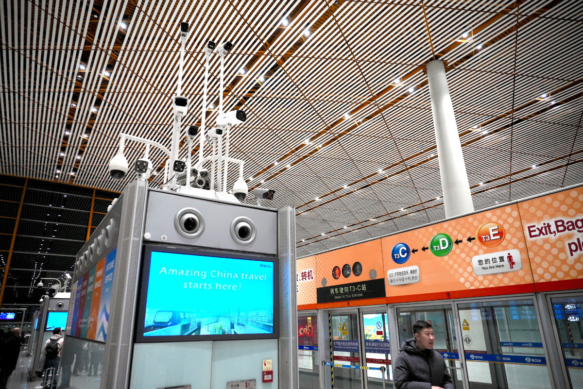 Surveillance cameras above a screen reading "Amazing China travel starts here!" monitor passengers at an airport in Beijing, China, on Dec. 21, 2024. (AP File Photo)