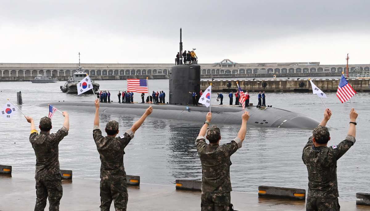 This handout photo taken on July 24, 2023 and provided by the South Korean Defense Ministry shows the USS Annapolis, a US nuclear-powered submarine, arriving as South Korean soldiers wave flags at a naval base in South Korea's southern island of Jeju. (AFP)