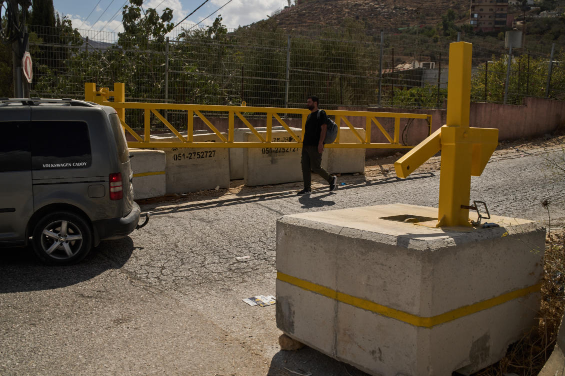 A Palestinian man walks past a gate set up by Israeli authorities at the entrance of the West Bank village of Sinjil, Tuesday, Sept. 30, 2025. (AP Photo/Leo Correa)