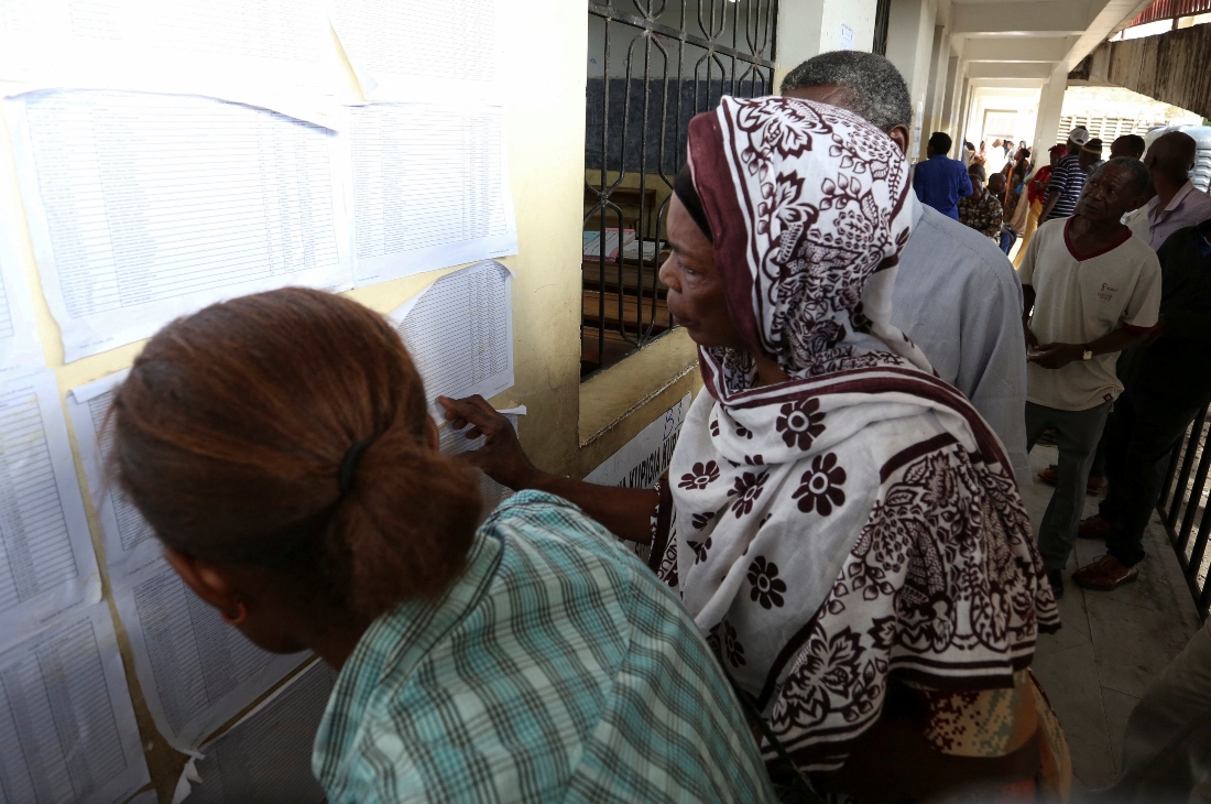Electorates look for their names on the notice board before queuing to cast their votes during the general election at a polling station in Dar es Salaam, Tanzania. (Reuters)