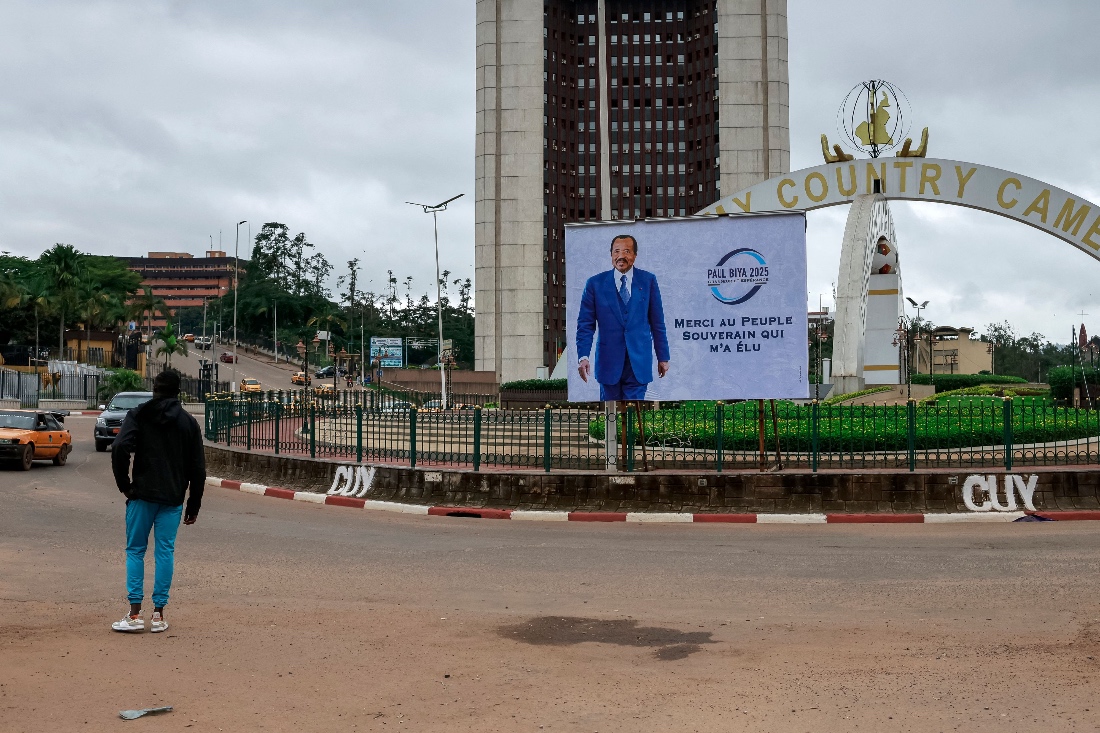 A pedestrian walks past a billboard of Cameroon's President Paul Biya reading: "I thank the sovereign people for electing me" on a street in Yaounde. (AFP)