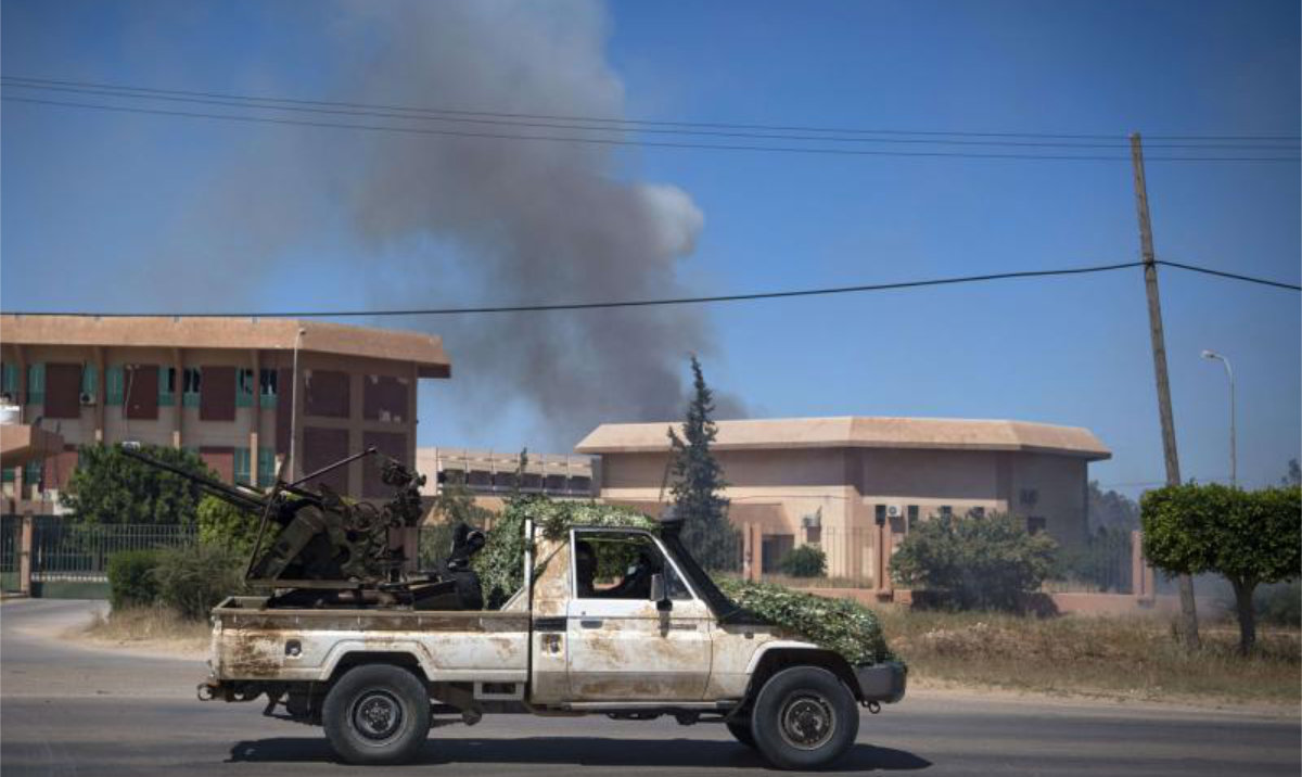 Smoke rises above buildings in Espiaa, about 40 kilometers south of the Libyan capital Tripoli. (AFP/File)