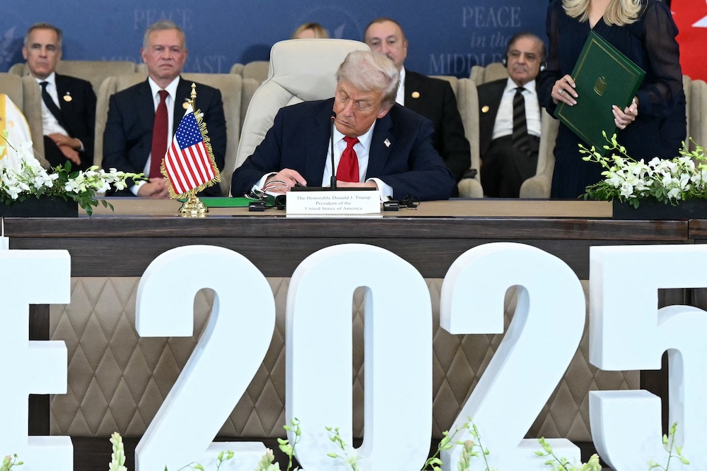US President Donald Trump signs a document during a summit on Gaza in Sharm El-Sheikh on Oct. 13, 2025. (AFP)