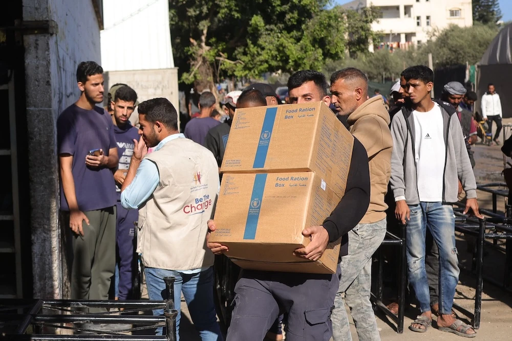 A Palestinian man collects food ration boxes provided by the World Food Programme in Gaza Strip on Oct. 27, 2025. (AFP)
