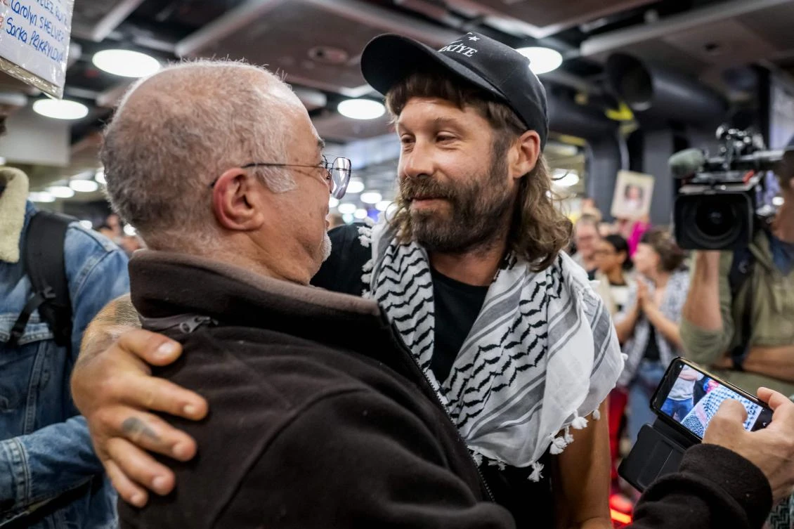 Romain Mouron (C), one of the Swiss activists who were sailing aboard vessels from the Global Sumud Flotilla, is comforted by a relative after landing at Geneva Airport from Istanbul after Israel stopped a Gaza-bound aid flotilla and detained hundreds of people, in Geneva on October 5, 2025. (AFP)