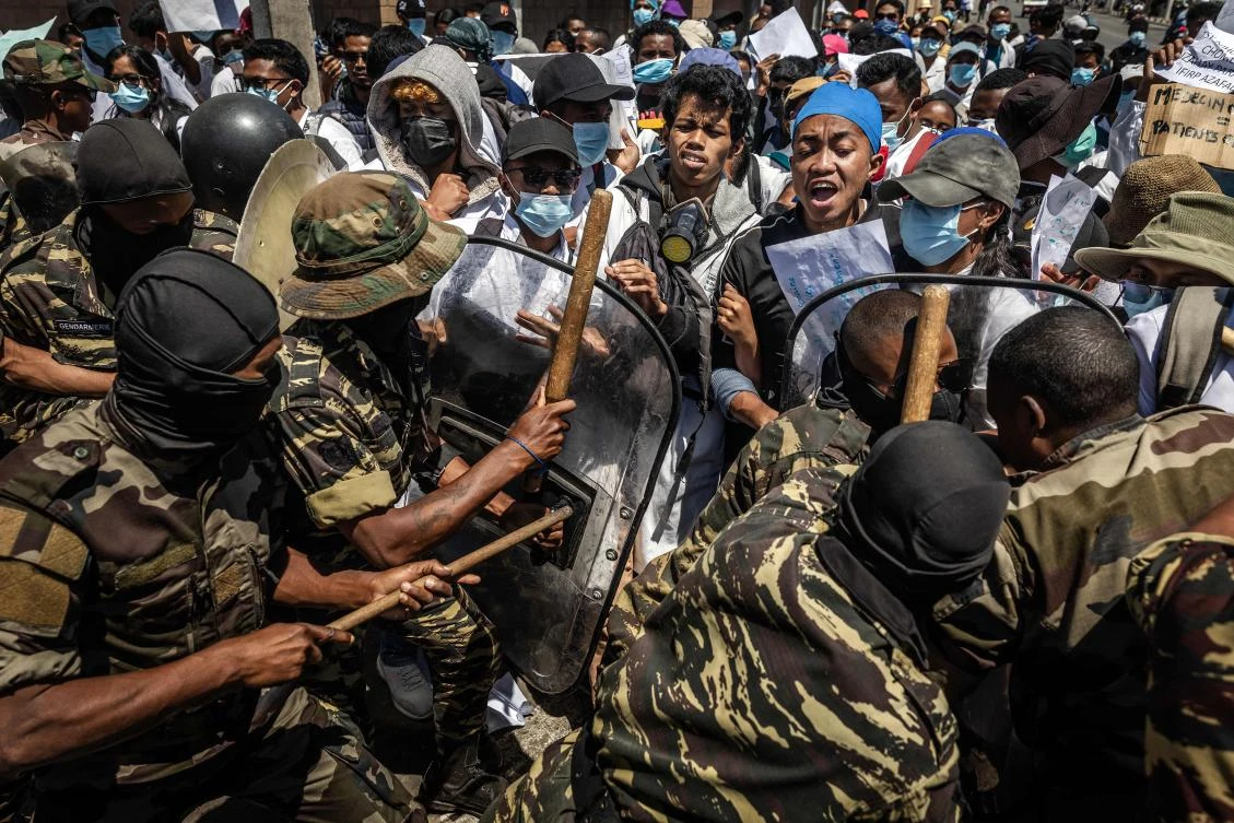 Medical students react as they are pushed with shields and clubs by Malagasy security forces during a demonstration in Antananarivo on Oct. 7, 2025. (AFP)