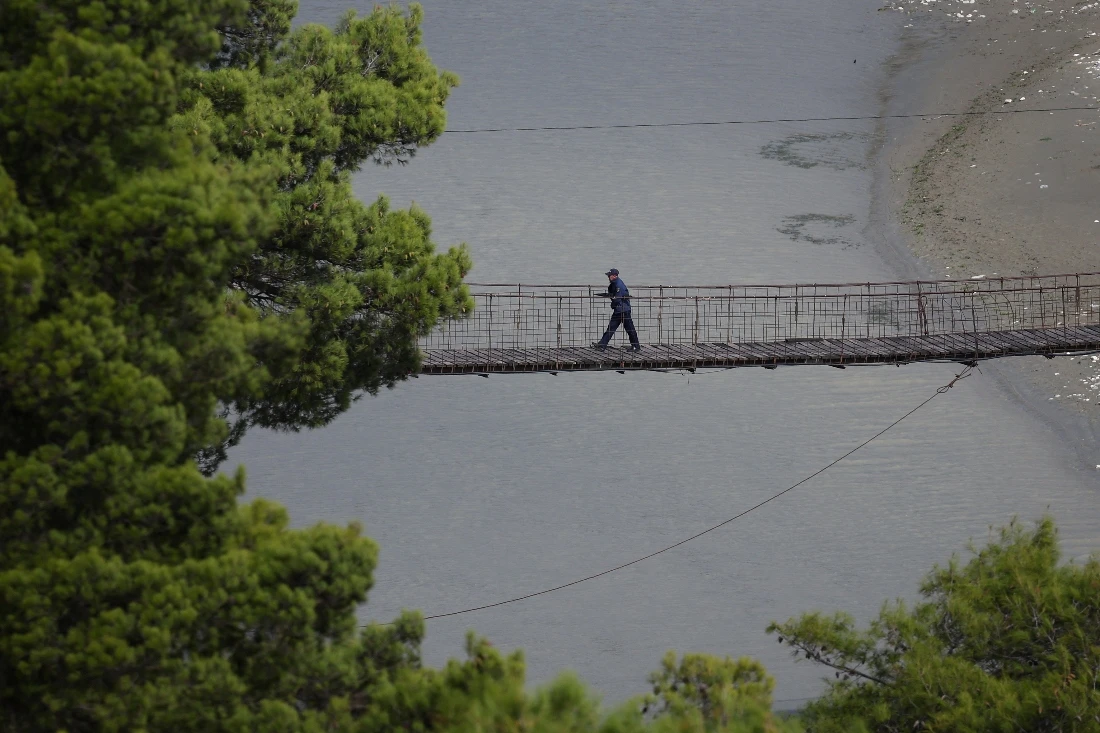 A man walks on a bridge by the Vjosa valley, recently designated a UNESCO site, in Tepelene, Albania. (Reuters)