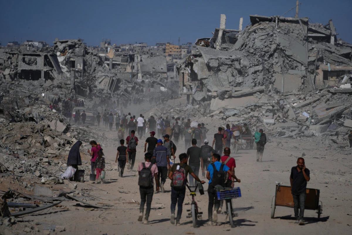 Displaced Palestinians walk past destroyed buildings as they return to their homes in the Zeitoun neighborhood of Gaza City on Oct. 10, 2025, after Israel and Hamas agreed on a ceasefire and the release of remaining hostages. (AP)
