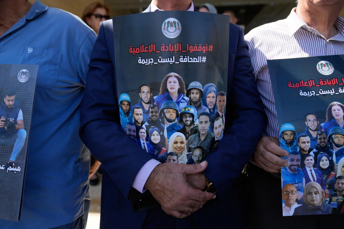 Above, Palestinian journalists carry posters with pictures of their colleagues, who were killed during the war in Gaza, during a rally to commemorate the second anniversary of the war in Gaza in the West Bank city of Ramallah on Oct. 8, 2025. (AP)