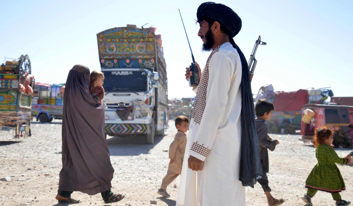 A Taliban security personnel stands guard as Afghans deported from Pakistan arrive at a registration centre at Takhta Pul in Kandahar province on October 9, 2025. (AFP)