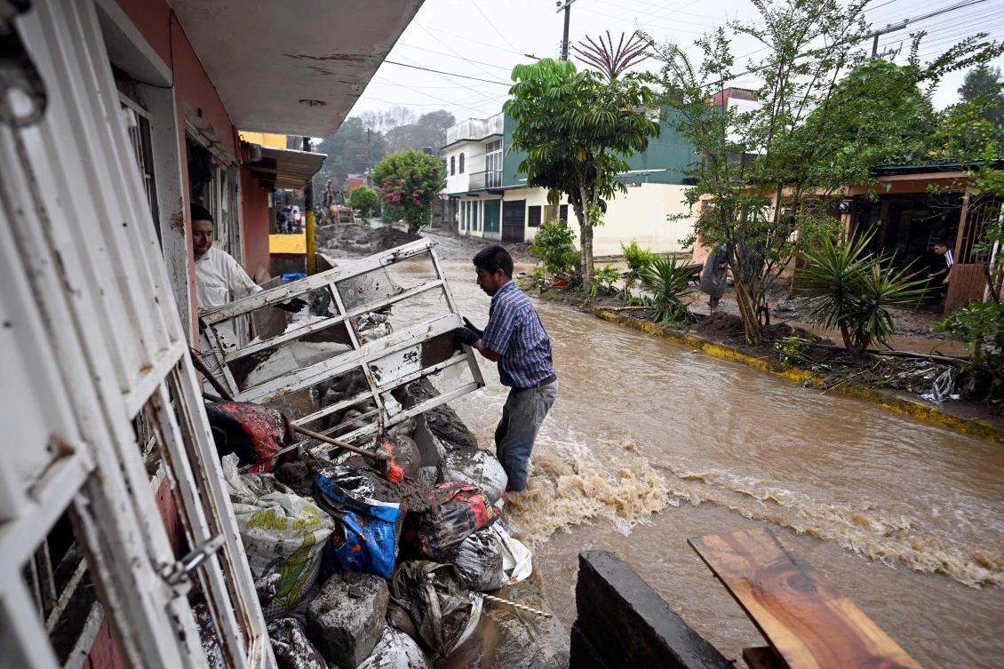 People work on a damaged house due to the rains in the municipality of Huauchinango, Puebla State, Mexico, Oct. 11, 2025. (AFP)