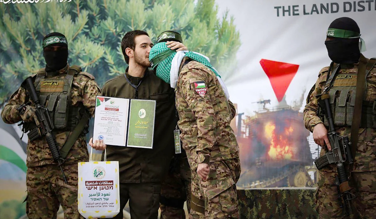 This handout image released by the Hamas Media Office on February 22, 2025, shows newly-released Israeli hostage Omer Shem Tov kissing the head of a Hamas fighter shortly after being set free in Nuseirat in the central Gaza Strip. (AFP)