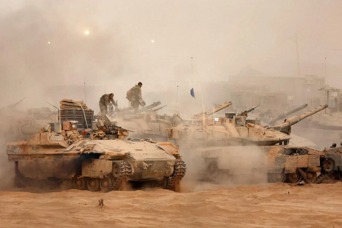 An Israeli army infantry-fighting vehicle (IFVs) deploys next to main battle tanks at a position along the Israel-Gaza border fence on October 10, 2025.(FIle/AFP)
