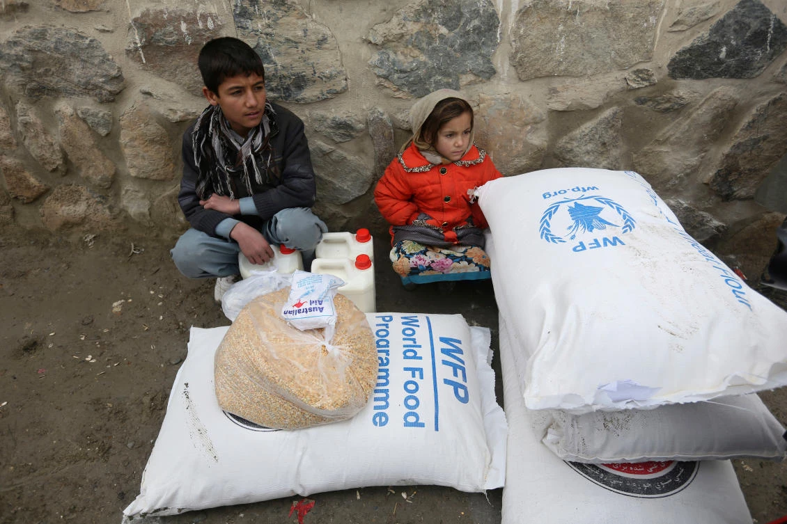 Above, children wait for transportation after receiving food donated by the World Food Programme in Kabul, Afghanistan. The UN’s food aid agency warned that nearly 14 million people could be forced into emergency levels of hunger. (AP)