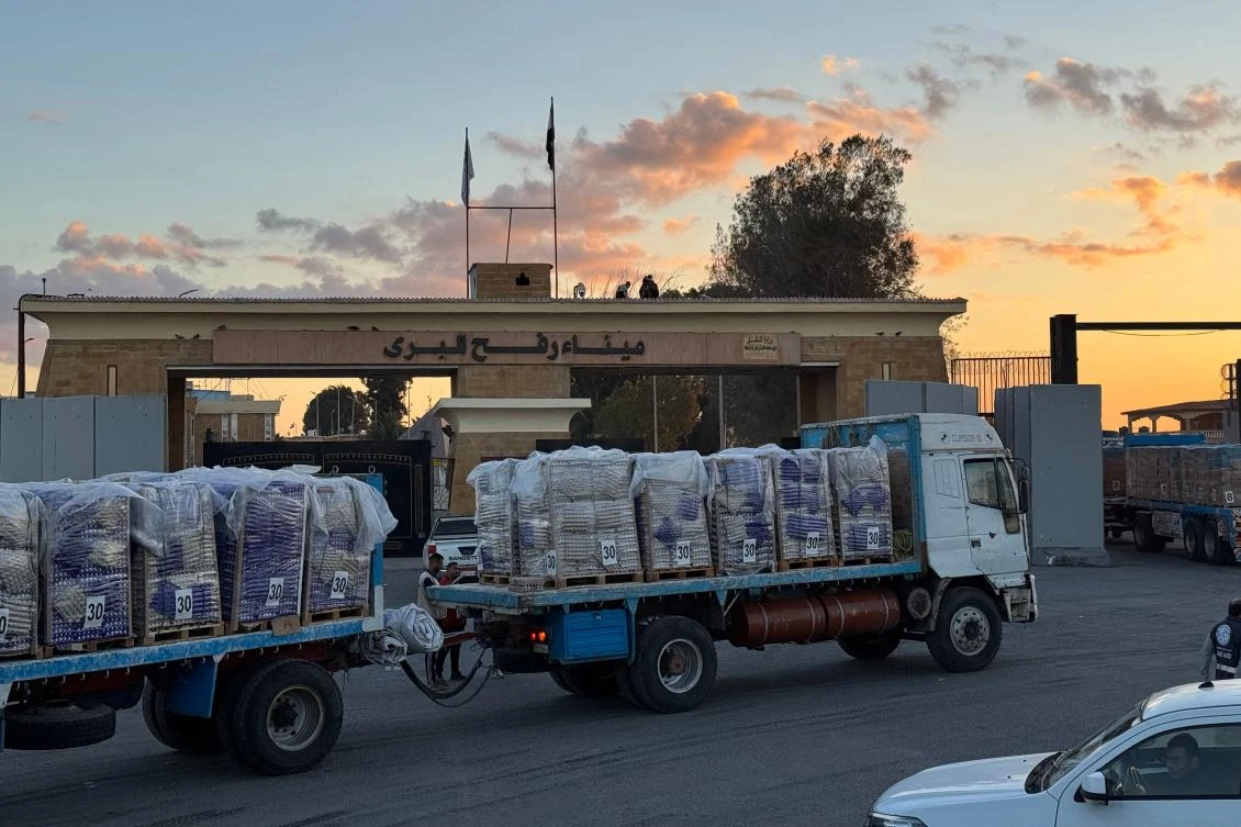 Trucks loaded with humanitarian aid on the Egyptian side of the Rafah crossing wait to cross into the Gaza Strip early on October 15, 2025, after Israel said it would allow the crossing to reopen for humanitarian aid to enter from Egypt into the Palestinian territory. (Photo by AFP)
