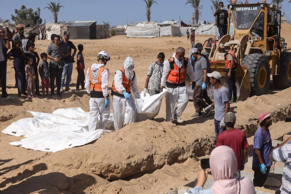Members of the Palestinian Civil Defense bury the remains of unidentified Palestinians at a cemetery in Deir Al-Balah, in the central Gaza Strip, on October 22, 2025. (AFP)