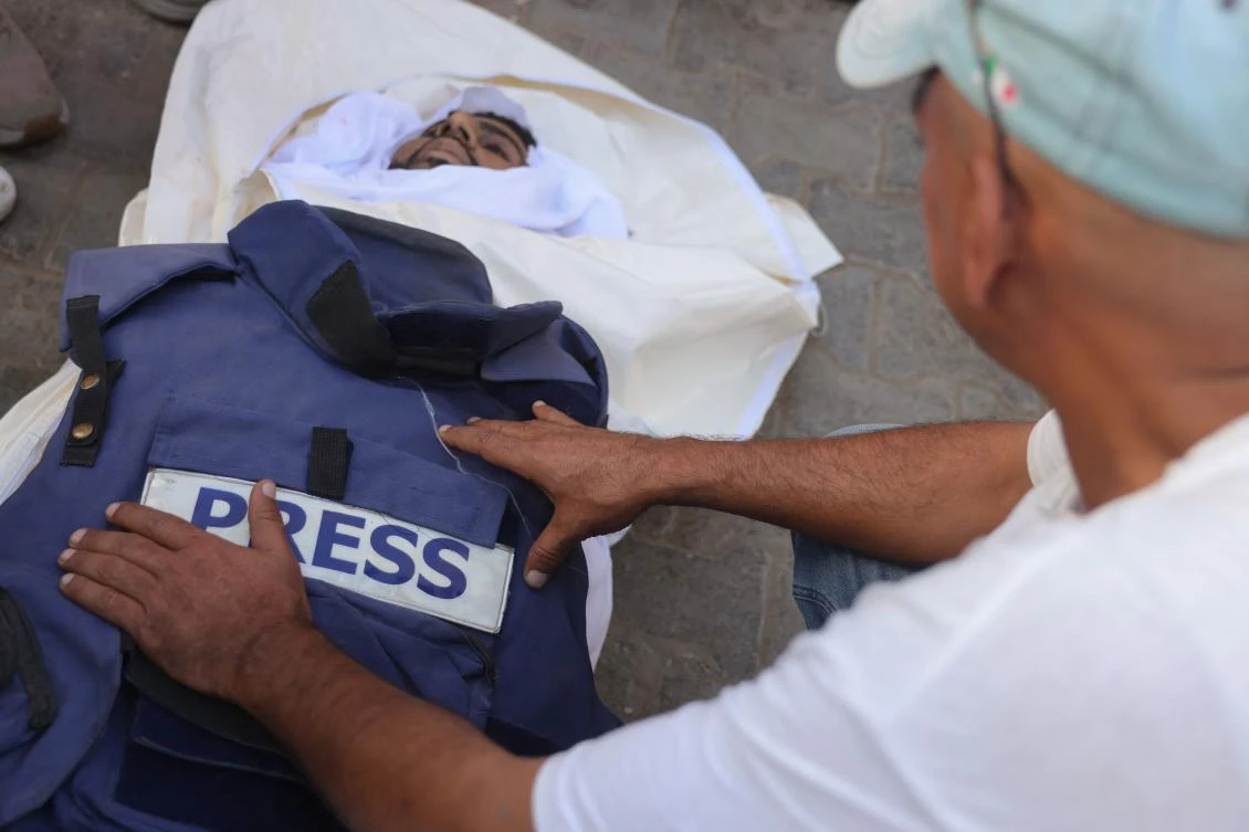 A man puts the bullet-proof press vest of Palestinian journalist Ahmad Abu Mteir, killed in an Israeli strike on a house used by journalists in the town of Zuwaida in the central Gaza Strip. (Photo by BASHAR TALEB / AFP)