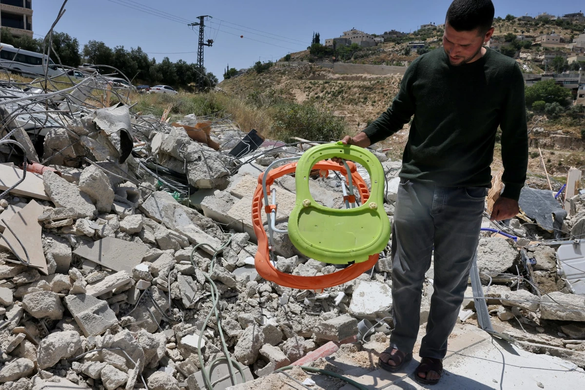 A man checks the debris of a house that was built without permission and demolished, in the east Jerusalem neighborhood of Jabal Mukaber, May 10, 2023. (AFP)