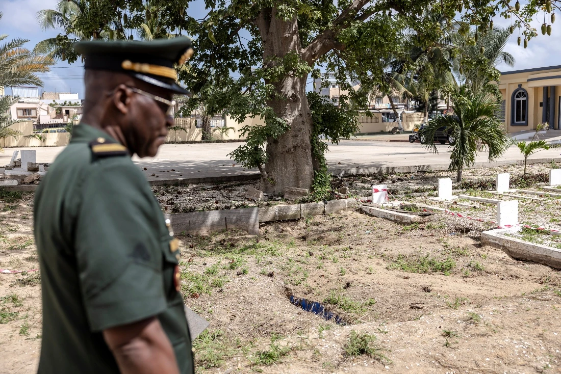 A member of the Senegalese Armed Forces stands next to an archeological excavation site at the Thiaroye Military Cemetery in Dakar, Senegal. (AFP)