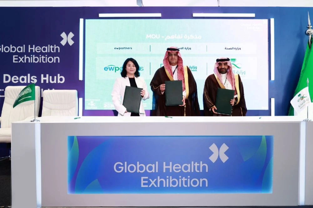 Meraee Al-Qahtani, Deputy Minister for Localization and Human Capital – Ministry of Health, right, Ammar Altaf, Assistant to the Deputy Minister of Investment, center, and Jessica Wong, Founder and Managing Partner of ewpartners take part in a signing ceremony during the Global Health Exhibition. (Supplied)