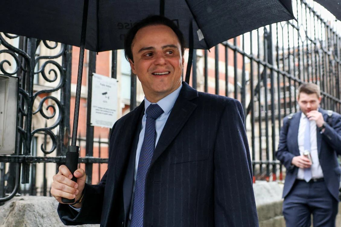 Former F1 driver Felipe Massa holds an umbrella near the High Court, where he is suing the governing FIA and former F1 chief Bernie Ecclestone, claiming he was the rightful 2008 world champion due to the Crashgate scandal at the Singapore Grand Prix, in London, Oct. 29, 2025. (Reuters)
