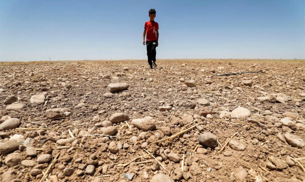 A boy walks through a dried up agricultural field in the Saadiya area, north of Diyala in eastern Iraq. (AFP/File)