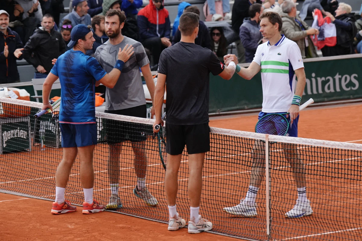 This photo taken on May 31, 2024, shows Frenchmen Nicolas Mahut (R) and Quentin Halys (2ndL) shaking hands with Austria's Alexander Erler (3rdL) and Lucas Miedler at the end of their men's doubles match in the French Open tennis tournament at the Roland Garros Complex in Paris. (AFP)